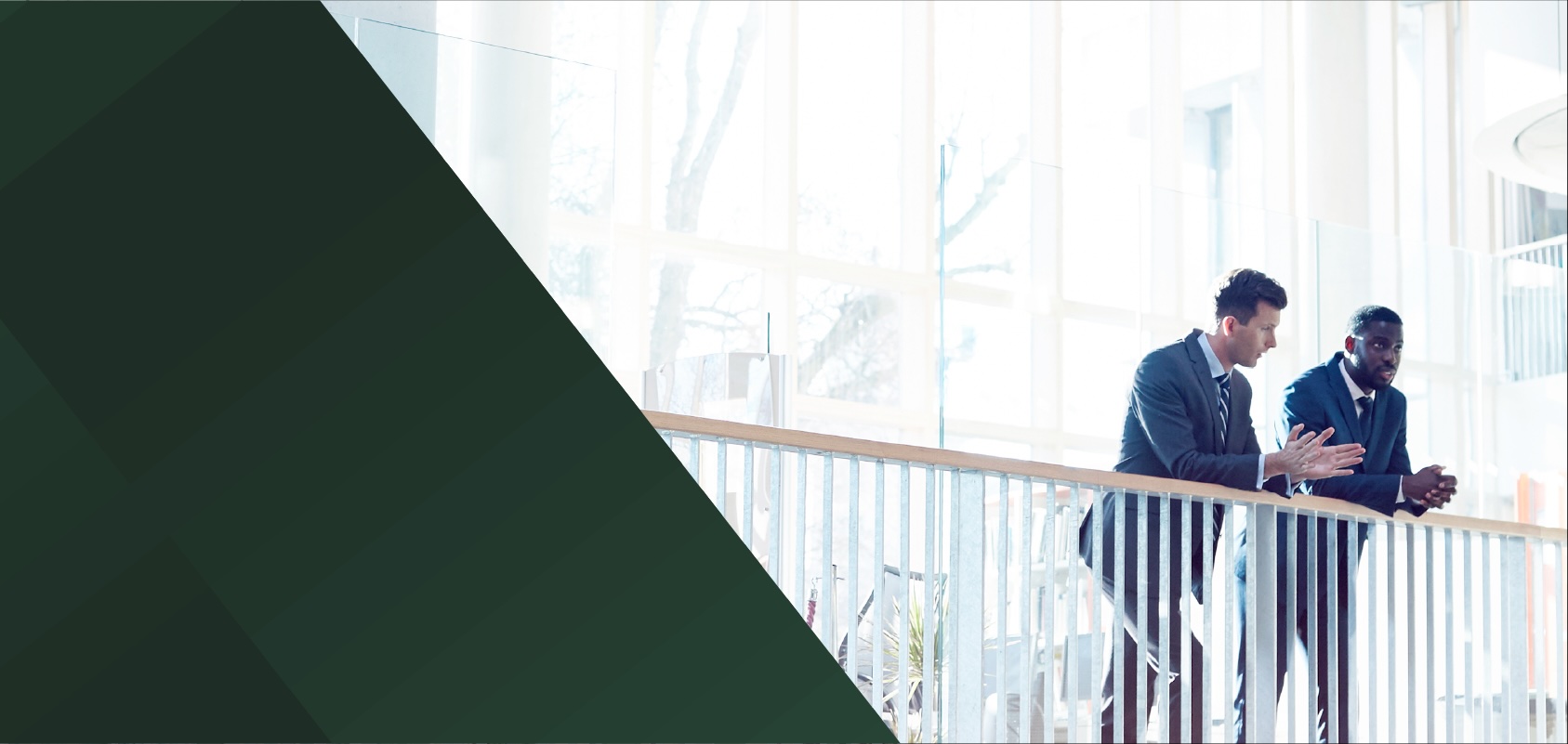 Two businessmen chatting at a balcony railing