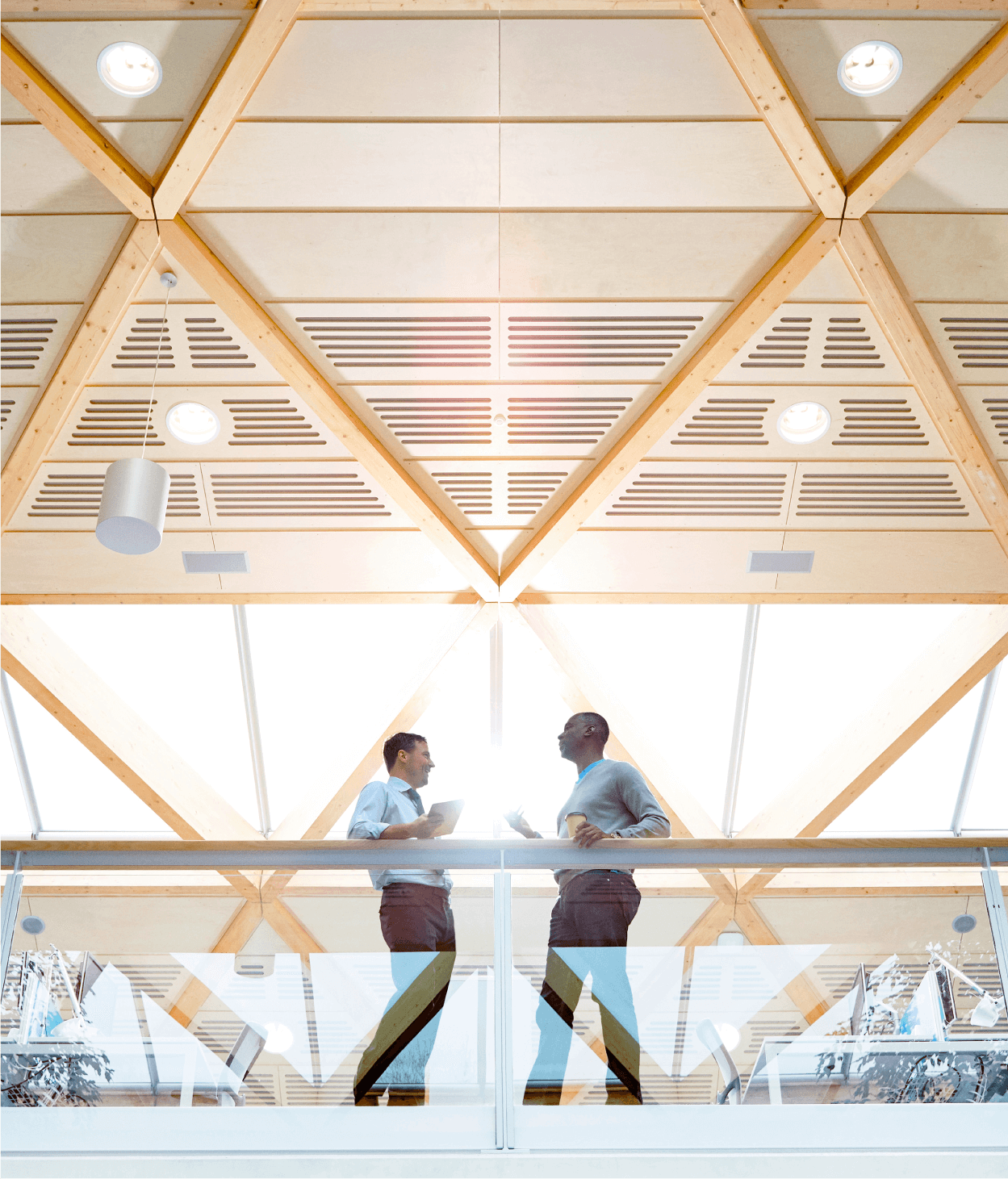 Two male businessmen speaking on balcony in open office space